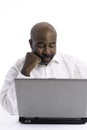 Portrait of thoughful and pensive African American software expert sitting front of a laptop computer