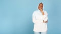 Portrait of thoughtful african american muslim woman in light headscarf touching chin and looking away at free space Royalty Free Stock Photo