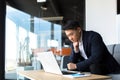 Portrait thoughtful Asian businessman working on a laptop computer at a modern office desk. Confident Focused pensive man Royalty Free Stock Photo