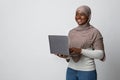 Thoughtful Black Muslim Woman With Laptop In Hands Over Light Studio Background