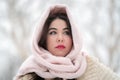 Portrait thoughtful brunette young woman in white fur coat and light pink scarf on head looking away Royalty Free Stock Photo