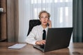 Portrait of thoughtful businesswoman talking phone typing laptop multitask in office. Portrait of busy female