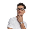 portrait of thoughtful casual man in white shirt with glasses looking up Royalty Free Stock Photo