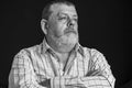 Portrait of a thoughtful Caucasian, bearded senior man in light shirt