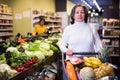 Elderly woman walking with shopping trolley in grocery shop Royalty Free Stock Photo