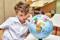 Portrait of a thoughtful elementary school student with a globe