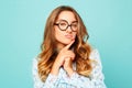 Portrait of a thoughtful girl wearing glasses. Pretty student over blue background Royalty Free Stock Photo