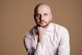 Portrait of thoughtful handsome bearded bald man in light pink s Royalty Free Stock Photo