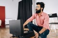 Portrait of thoughtful Indian hipster in glasses listening to music on old record player vinyl discs sitting on floor Royalty Free Stock Photo