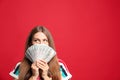 Portrait of thoughtful lottery winner with money on red background Royalty Free Stock Photo