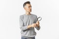 Portrait of thoughtful middle-aged man looking through magnifying glass, searching for something or reading, standing Royalty Free Stock Photo