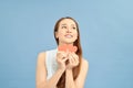 Portrait of thoughtful ponder girl in good mood having two little small red paper carton hearts in hands