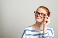 Portrait of thoughtful red haired woman with glasses on light background, space for text Royalty Free Stock Photo