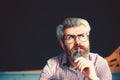 Portrait of thoughtful senior caucasian man with a grey beard and holding pen. Royalty Free Stock Photo