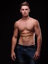 Healthy teenage guy shirtless on a black background. Sporty young men. Muscle building concept.
