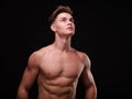 Healthy teenage guy shirtless on a black background. Sporty young men. Muscle building concept. Royalty Free Stock Photo