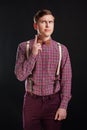 Portrait of thoughtful serious clever scientific man in vintage shirt bow tie with hairstyle keeping finger raised while standing Royalty Free Stock Photo