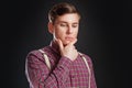 Portrait of thoughtful serious clever scientific man in vintage shirt bow tie with hairstyle keeping hand under chin while standin Royalty Free Stock Photo