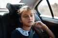 Portrait of thoughtful teenage girl, sitting in the backseat of the car.