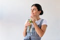 portrait of thoughtful woman with glass of detox drink looking away