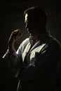 Portrait of a thoughtful 45-50-year-old man in a blue unbuttoned shirt of athletic build, contour lighting, dark background.Maybe Royalty Free Stock Photo