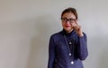 Portrait of a thoughtful young asian Chinese woman in eyeglasses looking up at copy space with hand on her head isolated over Royalty Free Stock Photo