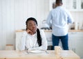 Portrait Of Thoughtful Young Black Woman Sitting At Table In Kitchen Royalty Free Stock Photo