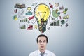 Portrait of thoughtful young businessman with creative business sketch with huge light bulb and other icons. Idea, innovation and Royalty Free Stock Photo