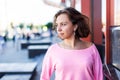 Portrait of thoughtful young Caucasian woman stands near modern building and looks away Royalty Free Stock Photo