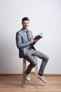 Portrait of a thoughtful young man with a pen and a diary in a studio, planning. Royalty Free Stock Photo