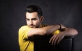 Portrait of thoughtful young man sitting on the chair. Royalty Free Stock Photo