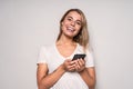 Portrait of a thoughtful young woman holding mobile phone and looking up at copy space isolated over white background Royalty Free Stock Photo