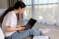 Portrait of a thougthful woman carefully looking in laptops screen. Home interior. The concept of online education and Royalty Free Stock Photo