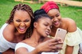 Portrait of three beautiful african-american women afro braids dreadlocks and turban taking pictures of yourself on the Royalty Free Stock Photo