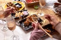 Portrait of three beautiful young women eating japanese food and drinking wine at home. Royalty Free Stock Photo