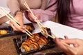 Portrait of three beautiful young women eating japanese food and drinking wine at home. Royalty Free Stock Photo