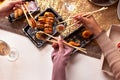 Portrait of three beautiful young women eating japanese food and drinking wine at home. Royalty Free Stock Photo