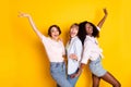 Portrait of three cheerful excited girls dark skin enjoy free time vacation disco isolated on yellow color background