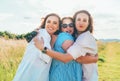 Portrait of three cheerful smiling women embracing during outdoor walking. They looking at the camera. Woman friendship, relations