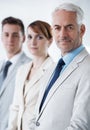 Portrait of three corporate business people , standing in a row and inside of the boardroom . Smiling friendly group of Royalty Free Stock Photo