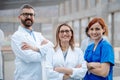 Portrait of three doctors, looking at camera, smiling. Healthcare team in medical uniforms in hospital. Royalty Free Stock Photo