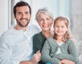 Portrait of three family members looking and smiling at the camera. Adorable little girl bonding with her grandmother Royalty Free Stock Photo