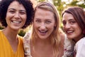 Portrait Of Three Female Friends Sitting Outdoors Together And Catching Up In Summer Garden At Home 