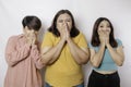 A portrait of three friends shocked, expressing disbelief feeling, isolated by a white background