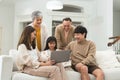 Portrait of three generations of Asian family, grandmother, grandfather, father, mother, little cute daughter using laptop, Royalty Free Stock Photo