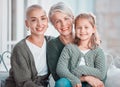 Portrait of three generations of females looking and smiling at the camera. Adorable little girl bonding with her mother