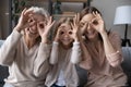 Portrait of three generations of women make funny gestures