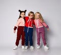 Portrait of three happy smiling kids best friends two girls and a boy in stylish sportswear stand together hugging. Royalty Free Stock Photo