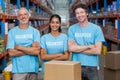 Portrait of three happy volunteers standing with arms crossed