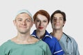 Portrait of three medical practitioners smiling together against gray background Royalty Free Stock Photo